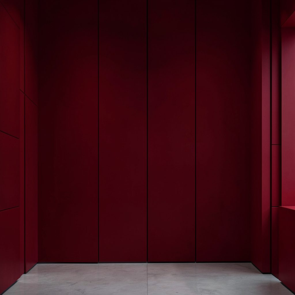 A neatly arranged display of creative tailoring materials and fabric scraps in warm burgundy and earthy tones, suggesting hands-on skills training